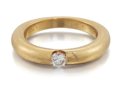 CARTIER - AN 18 CARAT GOLD ELLIPSE SOLITAIRE DIAMOND RING a round brilliant-cut diamond tension-set to a tapering shank. Stat