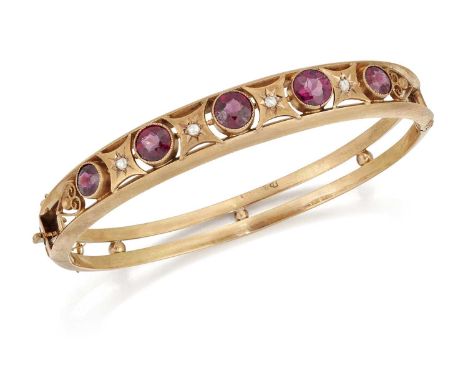 AN EARLY 20TH CENTURY 9 CARAT GOLD GARNET AND DIAMOND BANGLE five graduated round-cut garnets spaced by star-set rose-cut dia