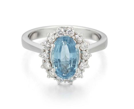 AN 18 CARAT WHITE GOLD AQUAMARINE AND DIAMOND CLUSTER RING an oval-cut aquamarine within a border of round brilliant-cut diam