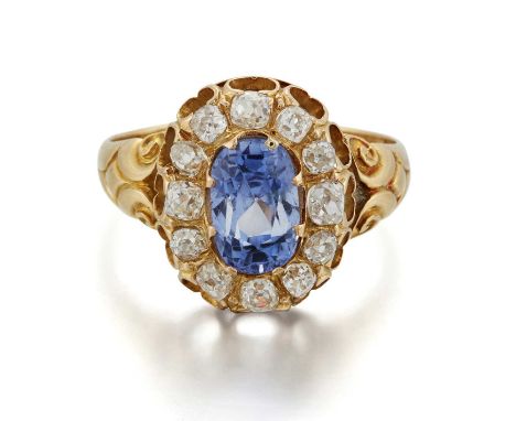 A LATE VICTORIAN SAPPHIRE AND DIAMOND CLUSTER RING an oval-cut sapphire within a border of old-cut diamonds, to foliate shoul