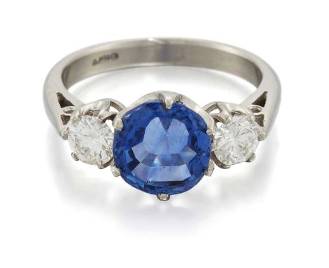 A PLATINUM SAPPHIRE AND DIAMOND THREE STONE RING a cushion-cut sapphire spaced by round brilliant-cut diamonds. Total diamond