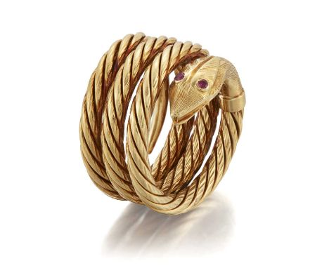 A SNAKE RING a coiled snake with textured scales and with ruby-set eyes. Marked '18K', 'Greece', ring size M, 16mm wide, 22.7
