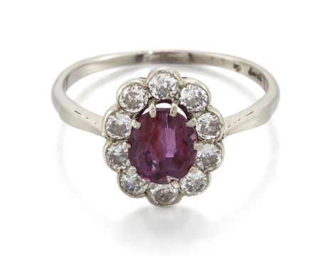 A RUBY AND DIAMOND CLUSTER RING an oval-cut ruby within a border of transitional round brilliant-cut diamonds. Estimated tota