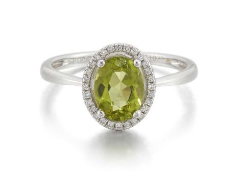 A PLATINUM PERIDOT AND DIAMOND CLUSTER RING an oval-cut peridot within a halo border of round brilliant-cut diamonds. Estimat