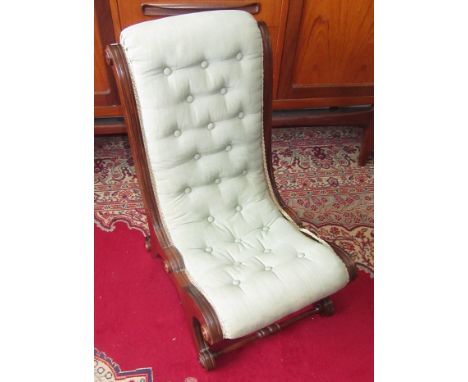 A Victorian button salon chair with mahogany frame and turned legs.