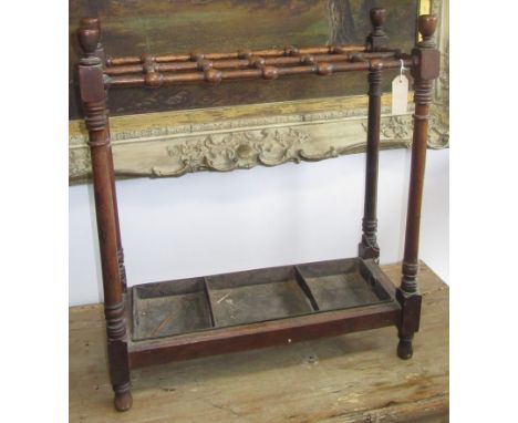 An Arts and Crafts mahogany stick stand, with twelve square sections joined by turned supports and a drop in metal tray, heig