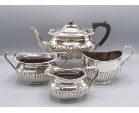 A spiral fluted and gadrooned three piece tea service and a half fluted sugar bowl.