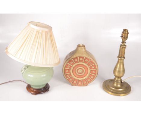 A studio pottery lamp base, height 22.5cm, with a linen shade, a brass lamp base, height 32cm and a Chinese celadon glaze lam