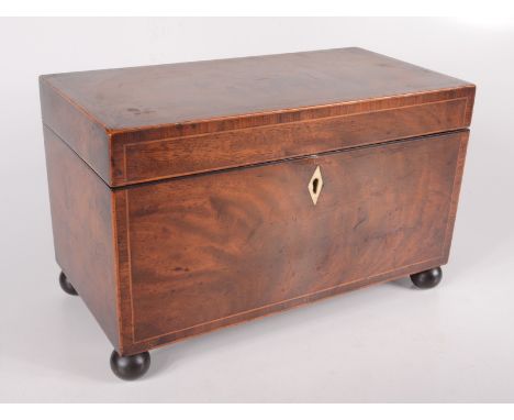 A George III mahogany tea caddy, with a fitted interior on bun feet, height 18cm, width 29cm, depth 15cm. 