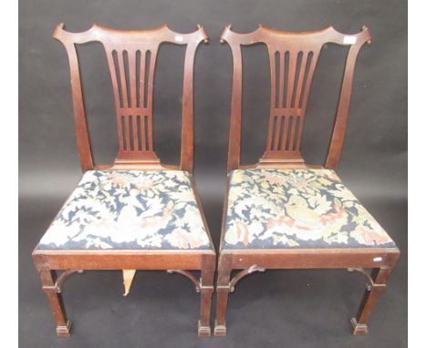 A pair of unusual 18th century mahogany dining chairs in Chippendale style, the shaped crest rails with tightly scrolling cor