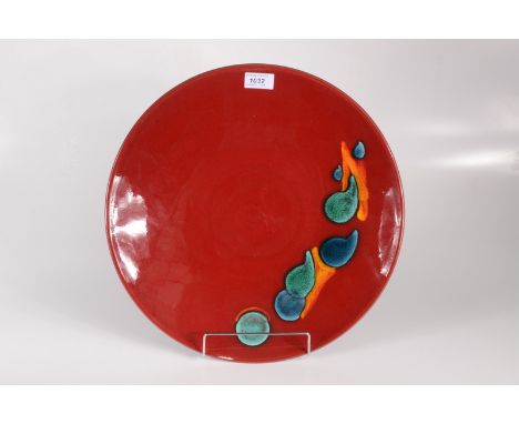 A large Poole Pottery shallow dish, the red ground with polychrome abstract design, diameter 39.5cm. 
