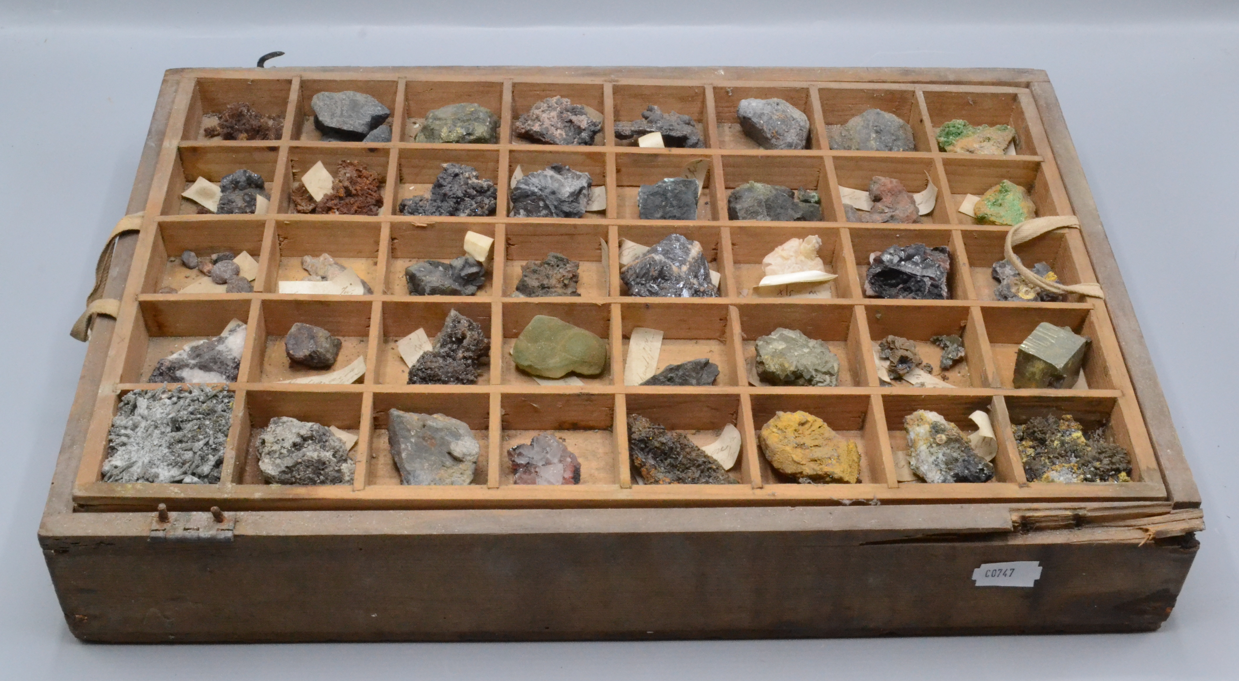 A selection of mineral specimens, in a pine collectors box with two