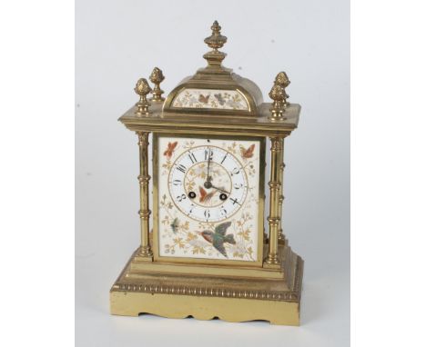 An Aesthetic Movement gilt brass mantel clock, late 19th century, the porcelain dial depicting a bird and butterflies amongst