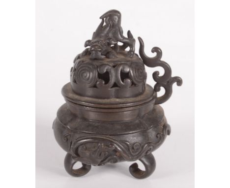 A Chinese bronze censer, 19th century, the pierced cover surmounted by a dog of fo, the body decorated with cloud scrolls on 