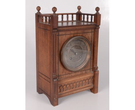An Arts and Crafts walnut mantel clock, the spindle filled gallery above a 9.5cm silvered dial, the movement signed RC, heigh