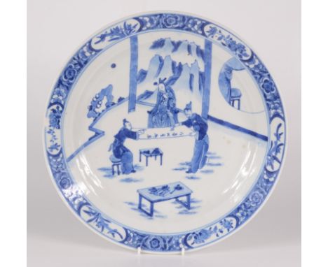 A Chinese blue and white porcelain dish, 18th century, decorated with scribes working on a scroll, a mountainous landscape to