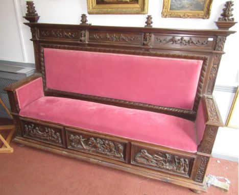 A large continental carved walnut settle, 19th century, the back carved with stylised dolphins and foliage and two portrait m
