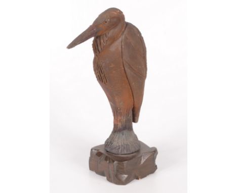 A ceramic model of pelican, on a carved wood base, height 25.5cm. 