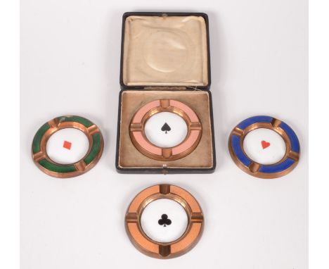 A set of four copper enamelled ashtrays, late 19th/early 20th century, each decorated with playing card symbols, in a black l