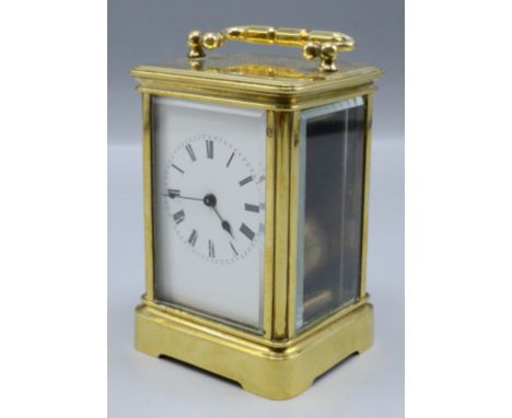 A brass carriage clock, the white enamelled dial with roman numerals, complete with winder, height of case 10cm, width 6.7cm,