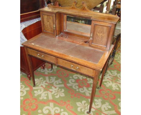 A late Victorian inlaid rosewood writing desk, the central mirror flanked by a pair of cupboard doors each opening to reveal 