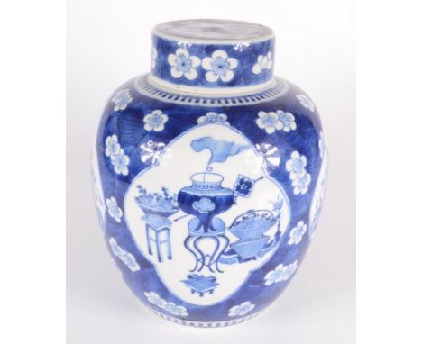 A Chinese blue and white porcelain prunus pattern ginger jar and cover, circa 1900, each of the four ivory ground cartouches 