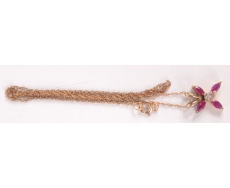 A ruby and diamond flowerhead pendant set in gold on fine gold chain. 