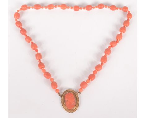 A pink coral necklace, at the centre a gold mounted coral portrait cameo.    Condition report:  34.7g including gold cameo.
