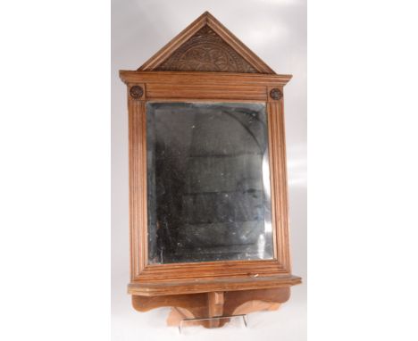 An Edwardian walnut wall mirror, with a rectangular bevelled plate above a single shelf, height 69cm, width 38.5cm. 