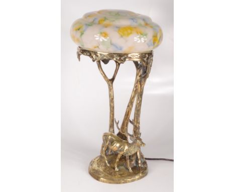 A gilt bronze table lamp, early 20th century, with mottled glass shade above trees and a deer, the base signed Jos Valenta an