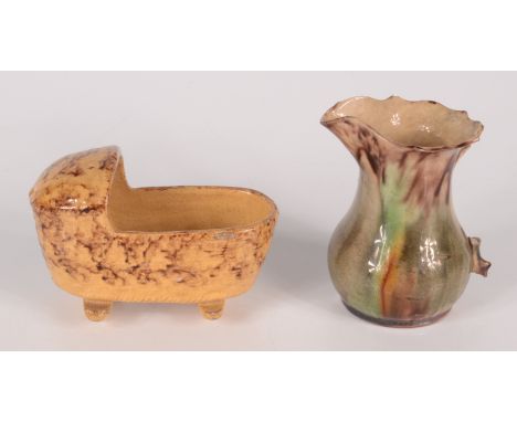 A small Whieldon type jug, 18th century, height 9cm, and a pottery cradle, early 19th century, paper label to base inscribed 