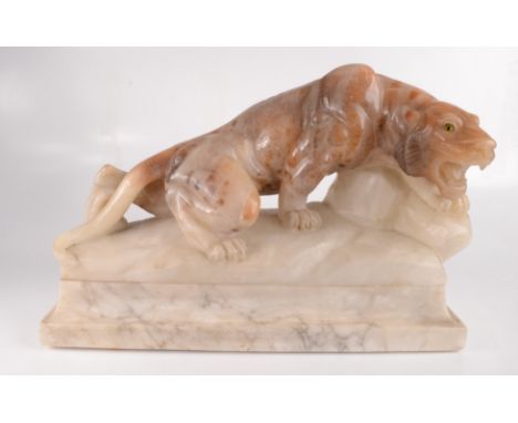 An alabaster lamp in the form of a prowling panther with green glass eyes, on a marble base, height 33cm, width 48cm, depth 1