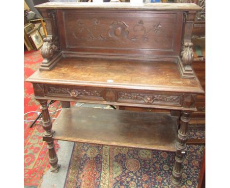 A Victorian carved oak buffet, the solid gallery back with scrolling vines and leaves, the lower part with two frieze drawers