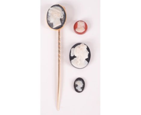 A gold stick pin with a carved hard stone cameo, together with three unmounted hard stone cameos.