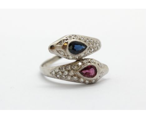 A white metal (tested high carat gold) ring set with ruby, sapphire and brilliant cut diamonds, (P).