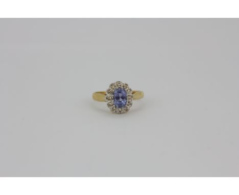 An 18ct yellow and white gold sapphire and diamond set cluster ring, (K).