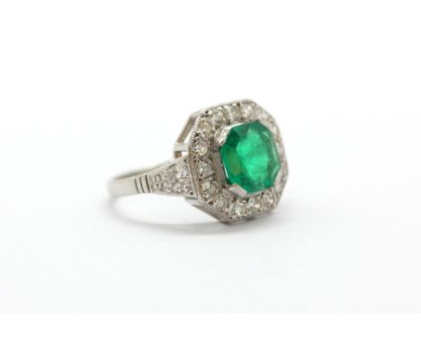 A 14ct white gold (stamped 585) ring set with an octagonal cut 1.42ct natural emerald surrounded by brilliant and single cut 