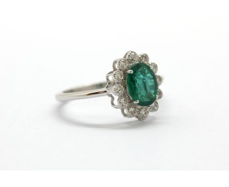 An 18ct white gold emerald and diamond set ring, approx. 1.21ct emerald, (O).