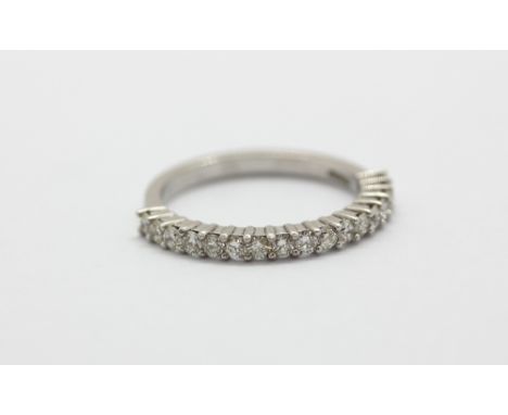 An 18ct white gold diamond set half eternity ring, (M).