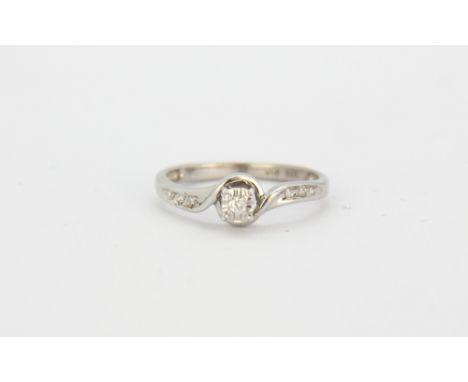 A 9ct white gold diamond set solitaire ring with diamond set shoulders, (M).