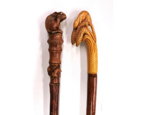 Two interesting carved wooden walking sticks, one with glass eyes, longest is 143cm (hiking stick)