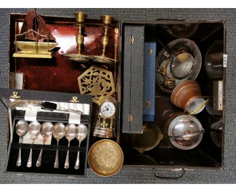A metal trunk containing brass candlesticks, cutlery and other items.