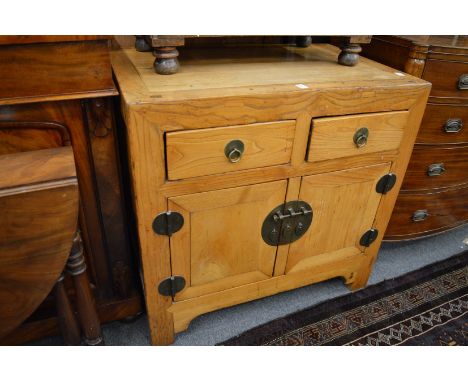 A Chinese light elm chest with two drawers and two cupboard doors.