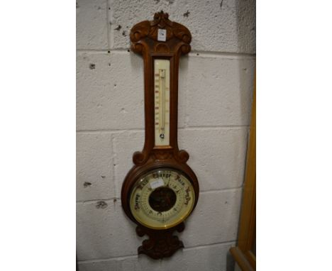 An oak cased barometer and thermometer.