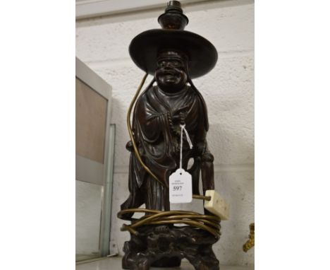 A Chinese carved wood figural table lamp.