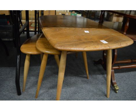 An Ercol light elm coffee table and two similar tables.