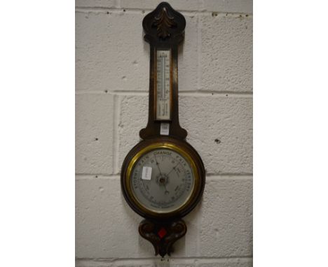 An oak cased aneroid barometer and thermometer.