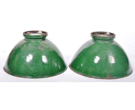 A pair of retro vintage 1930's industrial factory pendant light shades having a green enamel finish with white enamel interio