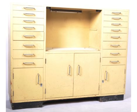 A retro vintage mid 20th Century dentist cabinet / chest having an open centre section with white glass flanked by banks of e