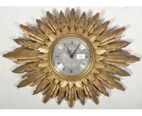 A 1950’s retro vintage Art Deco style gilt sunburst wall clock by James of London having a circular clock to the centre stran